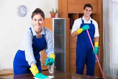 a couple of workers male and female cleaning a place.